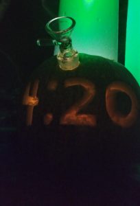 420 carved on a pumpkin with a bong sticking out